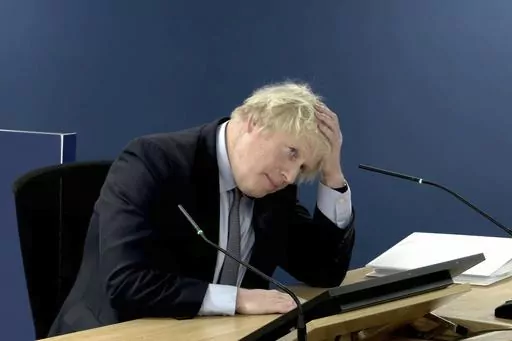 This image taken from the UK COVID-19 Inquiry live stream shows former British prime minister Boris Johnson giving evidence at Dorland House in London, Wednesday Dec. 6, 2023, during its second investigation (Module 2) exploring core UK decision-making and political governance. Johnson began two days of questioning under oath by lawyers for the judge-led inquiry about his initial reluctance to impose a national lockdown in early 2020 and other fateful decisions. (UK COVID-19 Inquiry via AP)