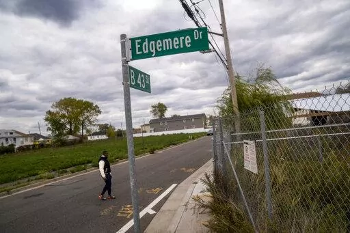 Dexter Davis, a neighborhood resident, walks the street between two abandoned residential lots 10 years after the area was severely damaged by Superstorm Sandy, Wednesday, Oct. 19, 2022, in the Edgemere neighborhood of the Queens borough of New York. There are no skateparks in Edgemere. No coffee shops. In fact, said Davis, a former NYC police officer, laments that there are few places for young people to go. "The things that they pump into the other communities around us are more positive (AP P