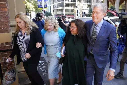 Steve Johnson, right, with his sisters, Terry, left, and Rebecca and his wife Rosemarie, second right, arrive at the Supreme Court in Sydney, Monday, May 2, 2022, for a sentencing hearing in the murder of Scott Johnson, Steve, Terry and Rebecca's brother. Scott White appeared in the New South Wales state Supreme Court for a sentencing hearing after he pleaded guilty in January to the murder of the Los Angeles-born Canberra resident Scott Johnson, whose death at the base of a North Head cliff was