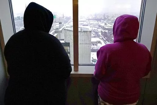 Two women, who allege abuse as minors by the ex-operations chief at New Hampshire's youth detention center, stand in their lawyer's office Thursday, Jan. 12, 2023, in Manchester, N.H. Twenty men and women say they were physically or sexually assaulted as children at New Hampshire's youth detention center by a man who went on to become the facility's chief of operations and later served on a committee advising the state on juvenile justice issues. (AP Photo/Charles Krupa)