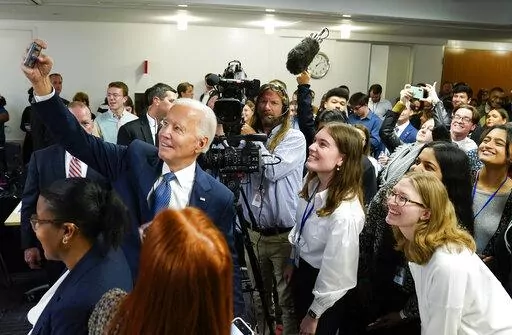 President Joe Biden takes a photo with a group of people after speaking during a visit to the Democratic National Committee Headquarters, Monday, Oct. 24, 2022, in Washington. (AP Photo/Evan Vucci)