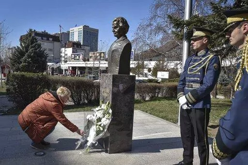 A woman lays a bouquet of flowers at the foot of a statue of former U.S. Secretary of State Madeleine Albright, in Pristina, Kosovo, Thursday, March 24, 2022. A monument in Kosovo, a snake named after her in Serbia. Madeleine Albright was either loved or hated in the Balkans for her pivotal role during the southern European region's wars of the 1990s. Following the former U.S. secretary of state's death on Wednesday at age 84, how her legacy is viewed from the Balkans mostly depends on whether o