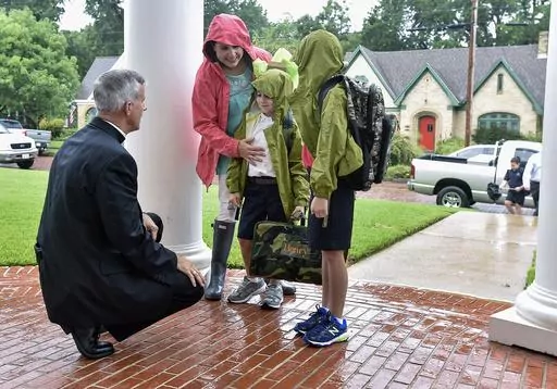 The Rev. Joseph Strickland, left, bishop of the Diocese of Tyler, goes to one knee Wednesday, Aug. 17, 2016, to greet children on the first day of school at St. Gregory Cathedral School in Tyler, Texas. Pope Francis on Saturday, Nov. 11, 2023, forcibly removed Strickland, a firebrand conservative prelate active on social media who has been a fierce critic of the pontiff and has come to symbolize the polarization within the U.S. Catholic hierarchy. (Andrew D. Brosig/Tyler Morning Telegraph via AP