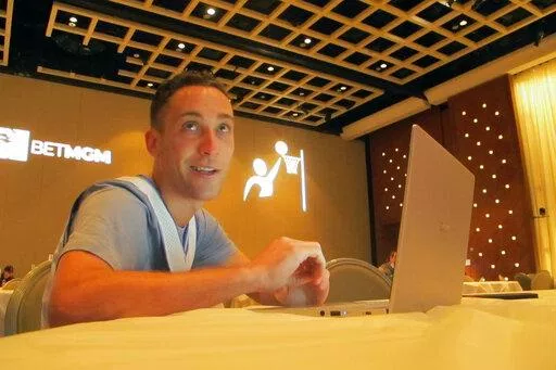 Jonathan Price of Staten Island, N.Y.,  researches picks for the March Madness college basketball championship tournament on March 19, 2021, at the Borgata casino in Atlantic City, NJ. On March 13, 2022, the American Gaming Association predicted that 45 million Americans will bet on this year's tournament. (AP Photo/Wayne Parry)