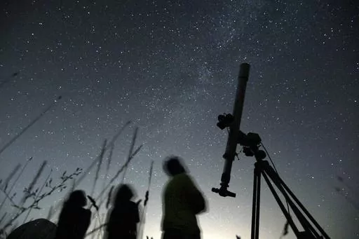 People look up to the sky at an observatory near the village of Avren east of the Bulgarian capital Sofia, Wednesday, Aug. 12, 2009. There's another chance to see five planets lined up in the sky, weather permitting. Saturn, Neptune, Jupiter, Uranus and Mercury will appear together before sunrise on Saturday., June 17, 2023. Jupiter and Saturn will be bright in the sky and easiest to see. Mercury will be the lowest to the horizon and harder to spot. And you'll need to break out binoculars or a t
