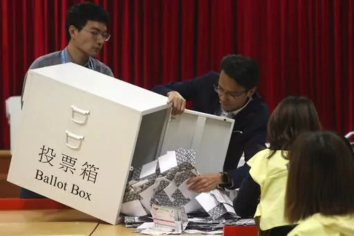 Election workers empty a ballot box to count votes for a district council election at a polling station in Hong Kong, Nov. 24, 2019. Hong Kong's leader on Tuesday, May 2, 2023, stepped up a campaign to shut down democratic challenges by unveiling plans to eliminate most directly elected seats on local district councils, the last major political representative bodies mostly chosen by the public. (AP Photo/Ng Han Guan, File)