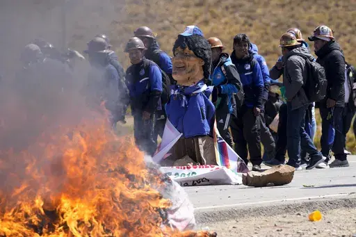 An effigy of former President Evo Morales burns on a road in Vila Vila, Bolivia, to block Morales supporters who are marching to the capital to protest the government of current President Luis Arce in an escalation of a political dispute between the two politicians, Tuesday, Sept. 17, 2024. (AP Photo/Juan Karita)