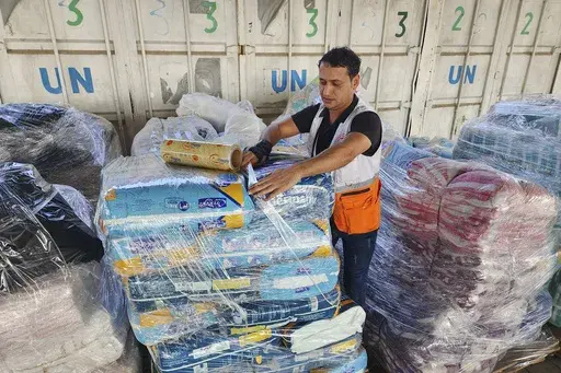 United Nations and Red Crescent workers prepare the aid for distribution to Palestinians at UNRWA warehouse in Deir Al-Balah, Gaza Strip, on Monday, Oct. 23, 2023. (AP Photo/Hassan Eslaiah, File)