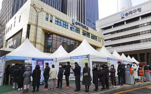 People wait for their coronavirus test at a testing station in Seoul, South Korea, Tuesday, Feb. 15, 2022. (Kwon Chang-hee/Newsis via AP)