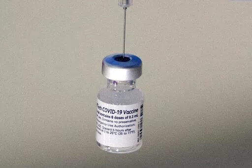 A syringe is placed into a vial of Pfizer-BioNTech vaccination at a COVID-19 clinic in Augusta, Maine, on Tuesday, Dec. 21, 2021. On Thursday, Oct. 20, 2022, Pfizer said it will charge $110 to $130 for a dose of its COVID-19 vaccine once the U.S. government stops buying the shots, but the drugmaker says it expects many people will continue receiving doses for free. (AP Photo/Robert F. Bukaty, File)