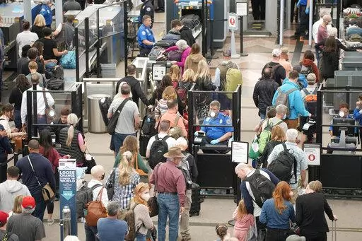 Travelers queue up move through the north security checkpoint in the main terminal of Denver International Airport, Thursday, May 26, 2022, in Denver. Airline travelers are not only facing sticker shock this Memorial Day weekend, the kick off to the summer travel season, but they're also battling a pileup of flight cancellations. More than 1,000 flights were canceled as of Saturday afternoon, May 28, according to flight tracking website FlightAware, after 2,300 cancellations on Friday. (AP Photo