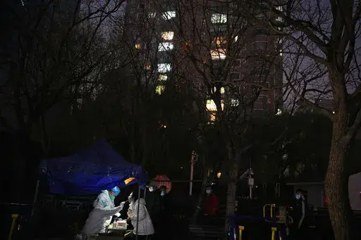 A resident gets swabbed for the COVID test outside a neighborhood in Beijing, Saturday, Nov. 19, 2022. (AP Photo/Ng Han Guan)