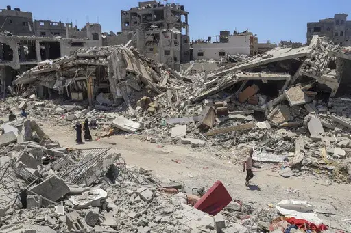 Palestinians walk through the destruction in the wake of an Israeli air and ground offensive in Jebaliya, northern Gaza Strip, on May 30, 2024. (AP Photo/Enas Rami, File)