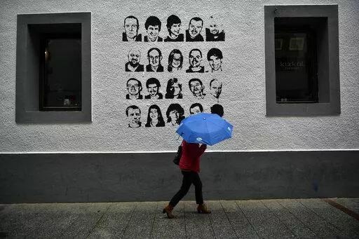 A woman shelters from the rain under an umbrella, while walking past a wall painted with portraits of prisoners of the Basque separatist armed group ETA, in the small village of Hernani, northern Spain, May 2, 2018. The United States is poised to remove five extremist groups, all believed to be defunct, from its list of foreign terrorist organizations. Several of these groups once posed significant threats, killing hundreds if not thousands of people across Asia, Europe and the Middle East. The 
