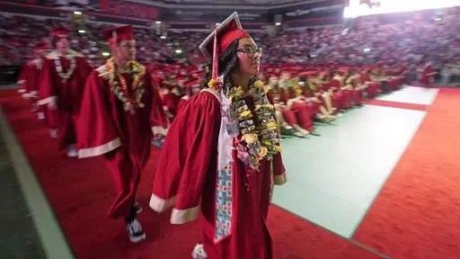 Amryn Tom graduates from Cedar City High School on Wednesday, May 25, 2022, in Cedar City, Utah. Tom is wearing an eagle feather given to her by her mother and a cap that a family friend beaded. (AP Photo/Rick Bowmer, File)