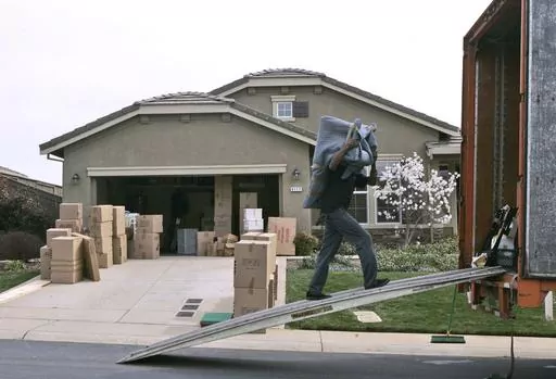 A mover carries a chair into a moving van parked at a home for sale in El Dorado Hills, Calif. Tuesday, March 11, 2008. Summer is the most expensive time of year to move. Though costs are down in 2023 compared to previous summers, prospective movers should still expect to pay a premium for their relocation. (AP Photo/Rich Pedroncelli, File)