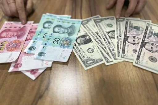 Paek H.O, who defected from the northeastern North Korean town of Musan in 2018, speaks in front of U.S. dollar and Chinese yuan notes during an interview in Seoul, South Korea, on May 3, 2023. North Korea has tolerated the widespread use of more stable foreign currencies like U.S. dollars and Chinese yuan since a bungled revaluation of the won in 2009 triggered runaway inflation and public unrest. Paek said she used the yuan to buy expensive goods and the won for cheap items such as sodas, vege