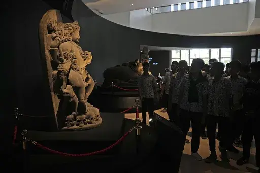 A group of students examine the statue of Hindu deity Bhairava which is a part of Indonesian historical artifacts repatriated from the Netherlands, at the National Museum in Jakarta, Indonesia, on Jan. 8, 2025. (AP Photo/Dita Alangkara)