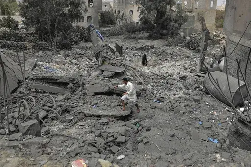 A Yemeni walks over the debris of a destroyed building following U.S. airstrikes in Sanaa, Yemen, Monday, March 24, 2025. (AP Photo)