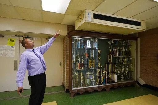 Jim Hill High School principal Bobby Brown, points out one of the outdated air-condition units that are installed throughout the Jackson, Miss., school, Jan. 12, 2023. A litany of infrastructure issues in the nearly 60-year-old school make for tough choices on spending COVID recovery funds on infrastructure or academics. (AP Photo/Rogelio V. Solis)