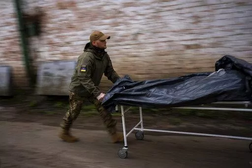 Darrell Loveless works moving dead bodies from refrigerated trucks to the morgue in Bucha, on the outskirts of Kyiv, Monday, April 25, 2022. (AP Photo/Emilio Morenatti)