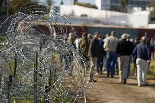 Concertina wire lines the path as members of Congress tour an area near the Texas-Mexico border, Jan. 3, 2024, in Eagle Pass, Texas. As congressional negotiators try to finalize a bipartisan deal on the border and immigration, their effort is drawing the wrath of hard-right lawmakers and former President Donald Trump. That vocal opposition threatens to unravel a delicate compromise. (AP Photo/Eric Gay, File)