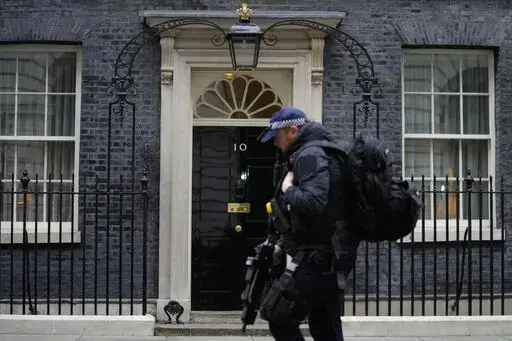 A police officer walks past 10 Downing Street in London, Tuesday, Jan. 25, 2022. London police say they are now investigating Downing Street parties during lockdown. Metropolitan Police Commissioner Cressida Dick revealed an investigation was underway in a statement before the London Assembly on Tuesday. Dick said Scotland Yard is now investigating "a number of events" at Downing Street. (AP Photo/Kirsty Wigglesworth)