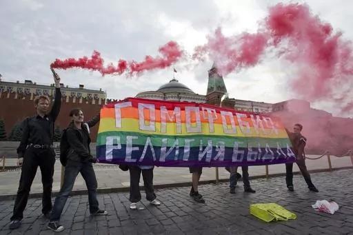 Gay rights activists hold a banner reading "Homophobia - the religion of bullies" during their action in protest at homophobia, on Red Square in Moscow, Russia, on July 14, 2013. Russian lawmakers on Wednesday June 14, 2023 approved in first reading a bill outlawing gender-affirming medical care and changing gender in official documents in yet another crippling blow to Russia's already beleaguered LGBTQ+ community. (AP Photo/Evgeny Feldman, File)