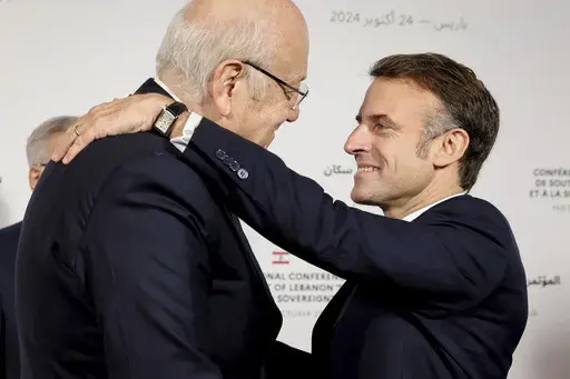 France's President Emmanuel Macron hugs Lebanon's Prime Minister caretaker Prime Minister Najib Mikati, left, during international conference for Lebanon in Paris, Thursday, Oct.24, 2024. (Alain Jocard, Pool via AP)