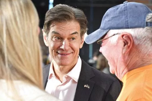 Mehmet Oz, the TV celebrity and heart surgeon who is running for the Republican nomination for U.S. Senate in Pennsylvania, talks with attendees Bob and Eileen Walker after Oz spoke at a town hall-style event at the Newtown Athletic Club, Feb. 20, 2022, in Newtown, Pa. (AP Photo/Marc Levy)