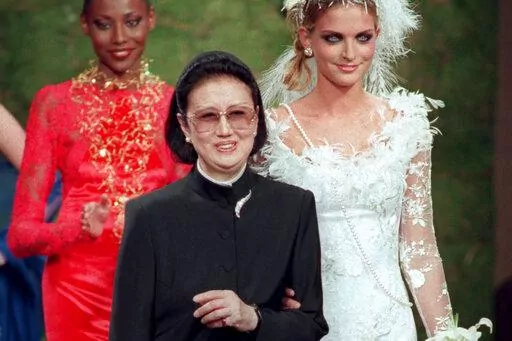 Japanese fashion designer Hanae Mori, center, is applauded by models after the presentation of her 1997-98 fall-winter haute couture collection presented in Paris, July 9, 1997. Mori, known for her elegant signature butterfly motifs, has died, according to the Hanae Mori Office. She was 96. (AP Photo/Michel Lipchitz, File)