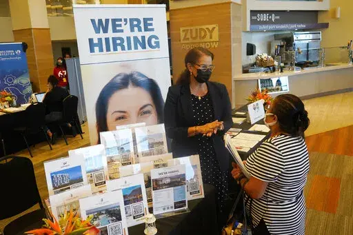 Marriott human resources recruiter Mariela Cuevas, left, talks to Lisbet Oliveros, during a job fair at Hard Rock Stadium, Friday, Sept. 3, 2021, in Miami Gardens, Fla.  Fewer Americans applied for unemployment benefits last week, as layoffs continue to decline amid a strong job market rebound. Jobless claims fell by 15,000 to 214,000 for the week ending March 12, 2022 down from the previous week's 229,000, the Labor Department reported Thursday, March 17.  (AP Photo/Marta Lavandier, File)