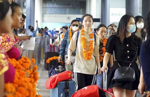 Chinese tourists arrive at Ngurah Rai international airport in Bali, Indonesia on Sunday, Jan. 22, 2023. A direct flight from China landed in Indonesia's resort island of Bali for the first time on Sunday in nearly three years after the route was cancelled due to the pandemic. (AP Photo/Firdia Lisnawati)