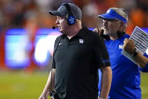 Kentucky head coach Mark Stoops, left, paces the sideline during the second half of an NCAA college football game against Florida, Saturday, Sept. 10, 2022, in Gainesville, Fla. (AP Photo/John Raoux)