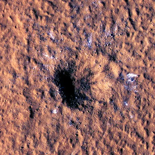 In this image made available by NASA on Thursday, Oct. 27, 2022, boulder-size blocks of water ice are seen around the rim of an impact crater on Mars, as viewed by the High-Resolution Imaging Science Experiment (HiRISE camera) aboard NASA's Mars Reconnaissance Orbiter. The crater was formed Dec. 24, 2021, by a meteoroid strike in the Amazonis Planitia region. (NASA/JPL-Caltech/University of Arizona via AP)