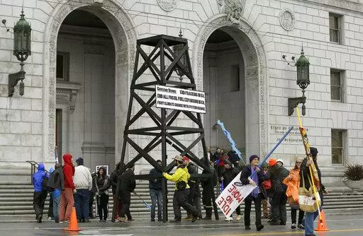 Protesters prepare to take down a makeshift oil derrick that was set up in front of the California State Office Building to protest fracking in San Francisco on Feb. 6, 2015. Leasing for new oil and gas drilling on federal land in central California is temporarily blocked under a settlement announced Monday, Aug. 1, 2022, between the state and the U.S. Bureau of Land Management. (AP Photo/Jeff Chiu, File)