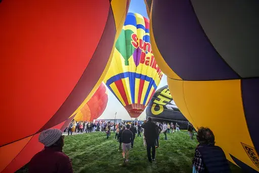 Spectators watch as hot air balloons take off during the mass ascension at the 52nd Albuquerque International Balloon Fiesta in Albuquerque, N.M., on Saturday, Oct. 5, 2024. (AP Photo/Roberto E. Rosales)