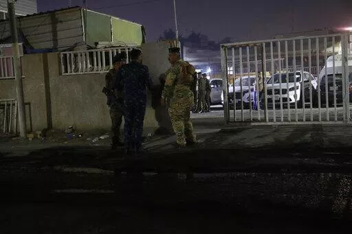 Iraqi security forces gather outside a morgue of Sheikh Zayed Hospital in Baghdad, Monday, Nov. 7, 2022. Assailants shot dead an American aid worker in Baghdad on Monday in a rare killing of a foreigner in the Iraqi capital in recent years, two police officials said. (AP Photo/Hadi Mizban)