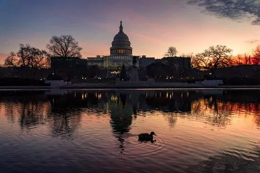 The sun rises behind the Capitol in Washington, early Wednesday, Dec. 14, 2022. Congressional leaders have unveiled a $1.7 trillion spending package early Tuesday, Dec. 20, 2022, that includes another large round of aid to Ukraine, a nearly 10% boost in defense spending and roughly $40 billon to assist communities across the country recovering from drought, hurricanes and other natural disasters. (AP Photo/J. Scott Applewhite, File)