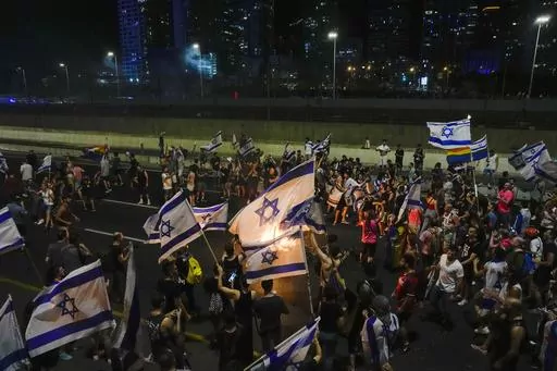 Israelis block a highway as they protest against plans by Prime Minister Benjamin Netanyahu's government to overhaul the judicial system, in Tel Aviv, Israel, Tuesday, July 18, 2023. (AP Photo/Ariel Schalit)