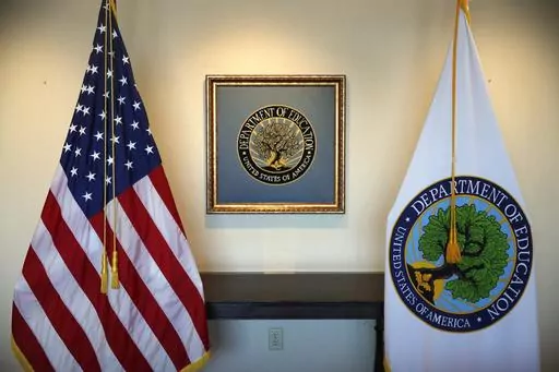 Flags decorate a space outside the office of the education secretary at the Education Department, Aug. 9, 2017, in Washington. College programs that leave graduates underpaid or buried in loans would be cut off from federal money under a proposal issued Wednesday, May 17, 2023, by the Biden administration, but the rules would apply only to for-profit colleges and a tiny fraction of programs at traditional universities. (AP Photo/Jacquelyn Martin, File)