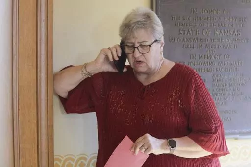 Kansas House Health Committee Chair Brenda Landwehr, R-Wichita, talks on the phone with GOP colleagues outside a caucus meeting and ahead of a vote on a proposed "born alive infants protection" law, Tuesday, April 4, 2023, at the Statehouse in Topeka, Kan. Under the measure, doctors could face lawsuits and criminal charges over allegations of not providing reasonable medical care for infants born during abortion procedures. But on Friday, April 14, Kansas Gov. Laura Kelly vetoed the bill. (AP Ph