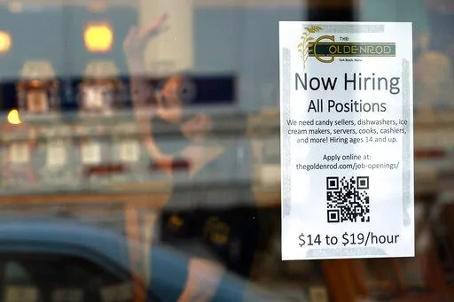 A sign advertises for help The Goldenrod, a popular restaurant and candy shop, Wednesday, June 1, 2022, in York Beach, Maine. America’s hiring boom continued in July as employers added a surprising 528,000 jobs despite raging inflation and rising anxiety about a recession.  (AP Photo/Robert F. Bukaty)