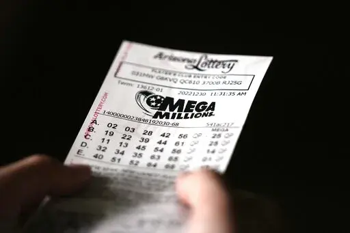A person holds a Mega Millions lottery ticket in Tempe, Ariz., Friday, Dec. 30, 2022. The jackpot for the Friday drawing is estimated at $640 million. (AP Photo/Ross D. Franklin)