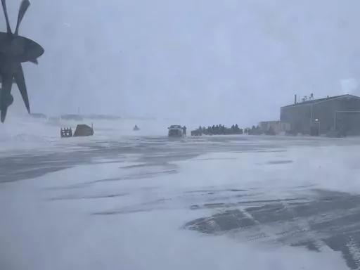 This March 28, 2023, photo shows townspeople in Gambell, Alaska, waiting in a snowstorm on four-wheelers to transport Alaska National Guard personnel from the air strip to the school for a ceremony. Sixteen Alaska National Guard members were honored for helping rescue the 11 crew members of a Navy plane that was shot down in 1955 by Soviet jet fighters and crash-landed about 8 miles from Gambell, on St. Lawrence Island, and 15 medals were presented posthumously. (AP Photo/Mark Thiessen)