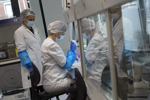 Staff handles forensic evidence at the laboratory of the International Commission on Missing Persons in The Hague, Netherlands, Friday, April 8, 2022. (AP Photo/Peter Dejong)
