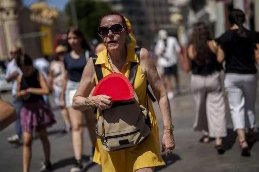 A woman fans herself in Madrid, Spain, July 10, 2023. A new study Tuesday, July 25, finds these intense and deadly hot spells gripping much of the globe in the American Southwest and Southern Europe could not have occurred without climate change. (AP Photo/Manu Fernandez, File)