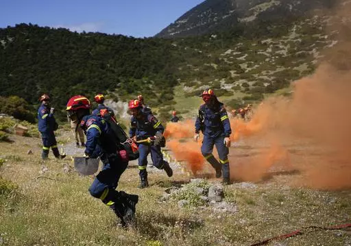 Firefighters of the 1st Wildfire Special Operation Unit, take part in a drill near Villia village some 60 kilometers (37 miles) northwest of Athens, Greece, Friday, April 19, 2024. Greece's fire season officially starts on May 1 but dozens of fires have already been put out over the past month after temperatures began hitting 30 degrees Celsius (86 degrees Fahrenheit) in late March. This year, Greece is doubling the number of firefighters in specialized units to some 1,300, adopting tactics from