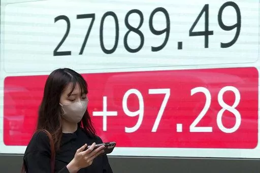 A person walks in front of an electronic stock board showing Japan's Nikkei 225 index at a securities firm Wednesday, Oct. 5, 2022, in Tokyo. Hong Kong’s share benchmark soared more than 5% on Wednesday as Asian shares tracked gains on Wall Street. (AP Photo/Eugene Hoshiko)