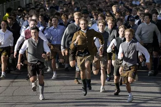 People run to enter the 188th 'Oktoberfest' beer festival in Munich, Germany, Saturday, Sept. 16, 2023. (AP Photo/Matthias Schrader)